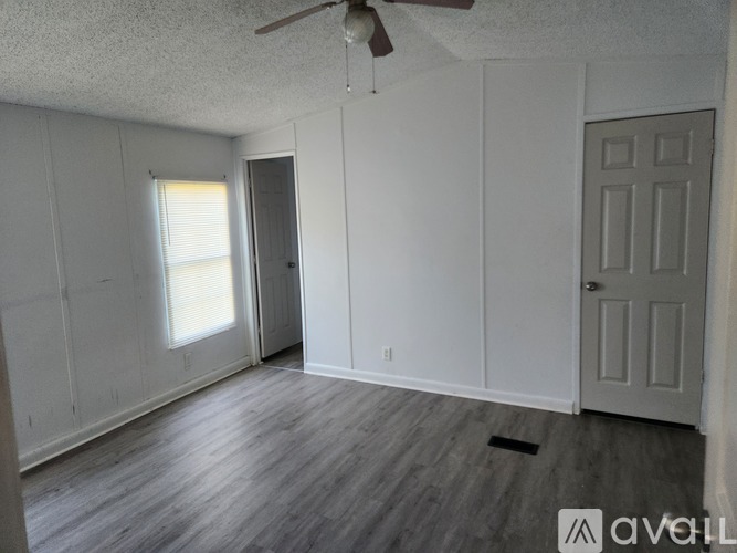 A room with a ceiling fan and two doors.