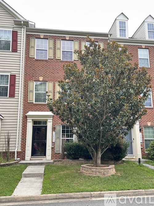 A tree in a planter in front of a red brick building.