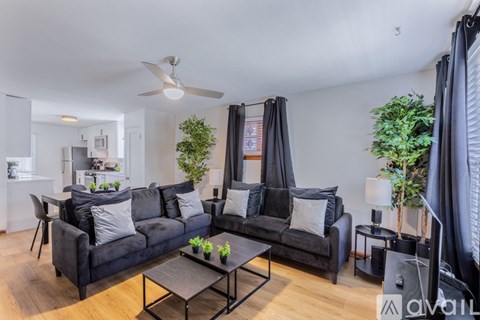A living room with a black couch and a coffee table.
