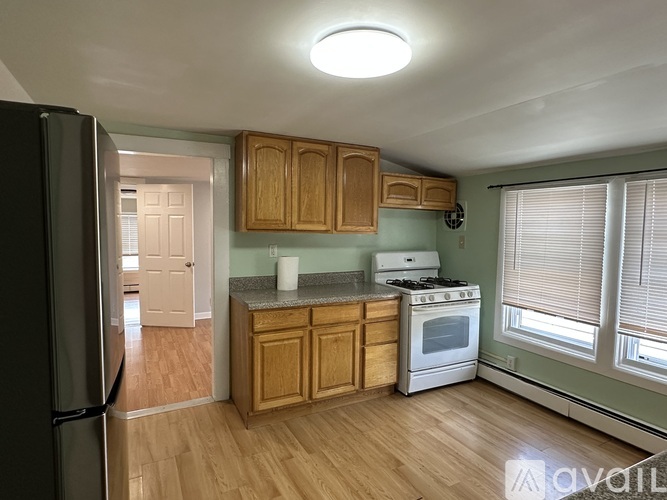 A kitchen with wooden cabinets and a white stove top oven.