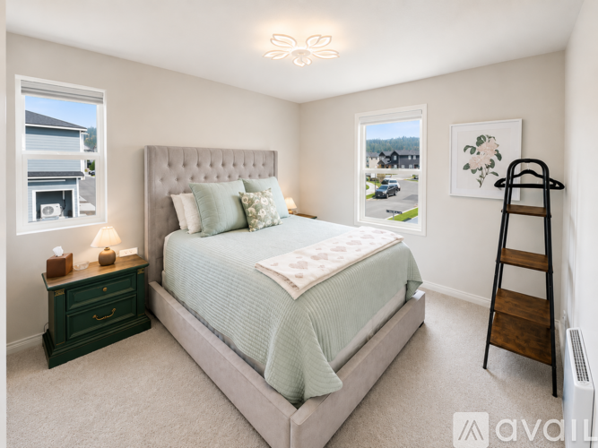 A bedroom with a bed, nightstand, and window.