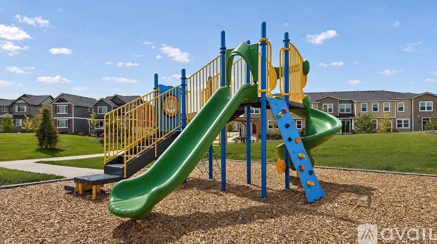 A playground with a green slide and a yellow and blue structure.