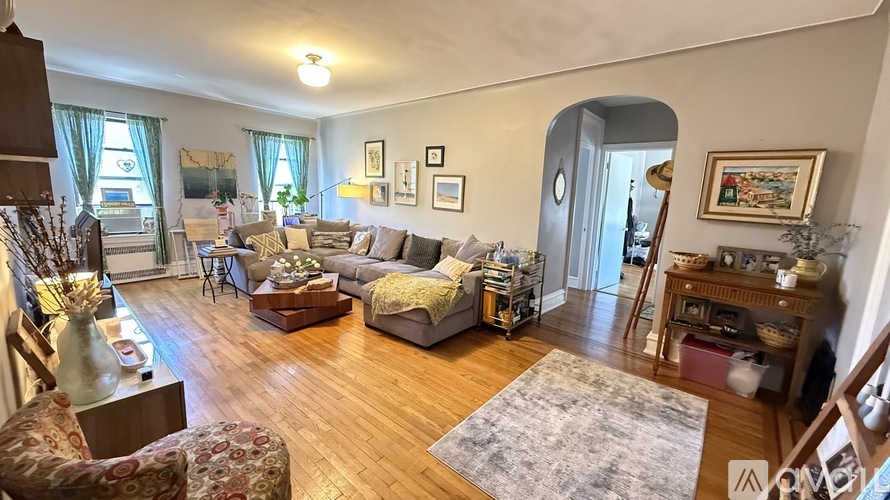 A living room with a sofa, a chair, a table, and a rug.