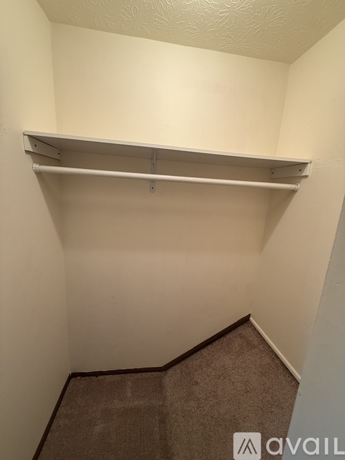 A small, empty room with a carpeted floor and a white wall.