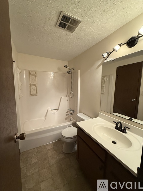 A bathroom with a toilet, sink, and bathtub.