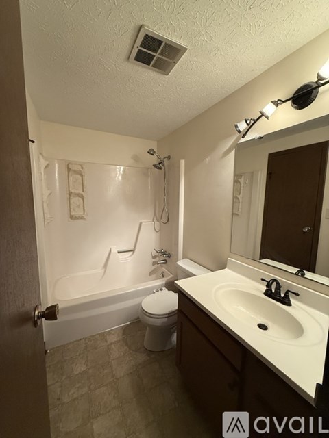A bathroom with a toilet, sink, and bathtub.