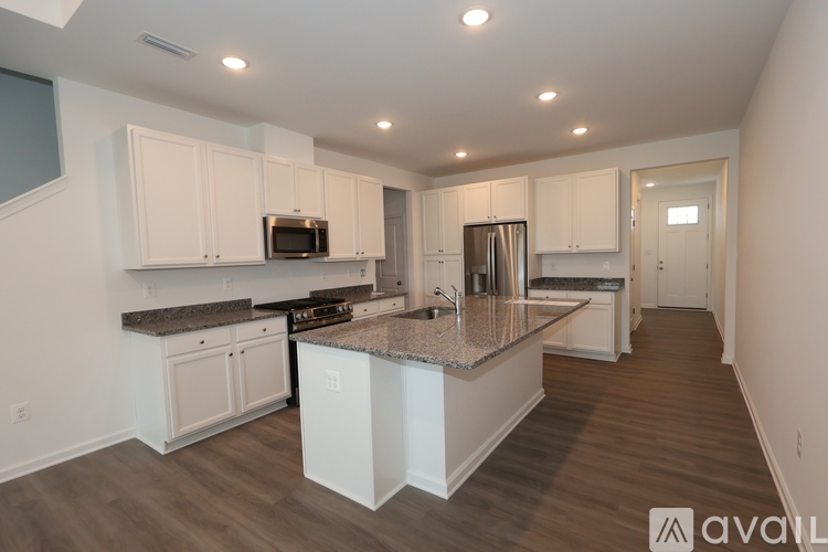 A kitchen with white cabinets and a granite countertop.