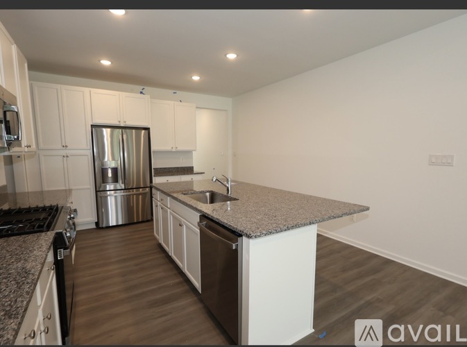 A kitchen with a granite countertop and stainless steel appliances.