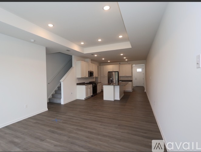 A spacious living room with a staircase leading to the upper floor.