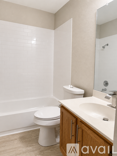 A white toilet sits in a bathroom next to a sink.