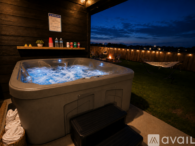 A hot tub with blue lights in the middle of a wooden deck.