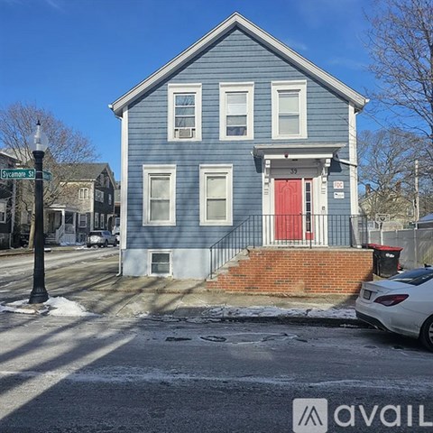 A blue house with a red door is located on a street corner.