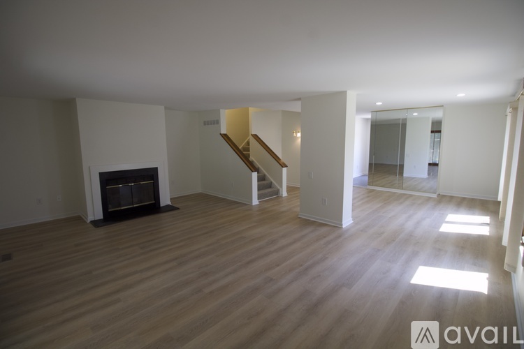 A spacious living room with a fireplace and wooden flooring.