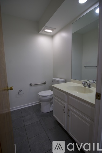 A bathroom with a toilet, sink, and mirror.