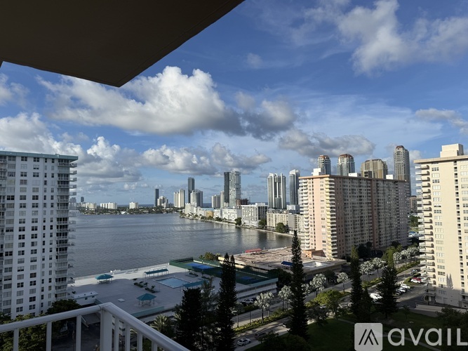 A cityscape with tall buildings and a body of water in the foreground.