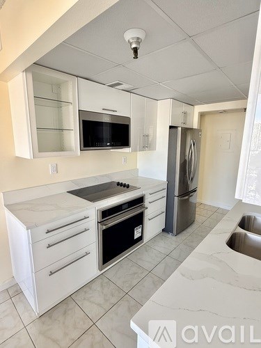A kitchen with white cabinets and appliances.