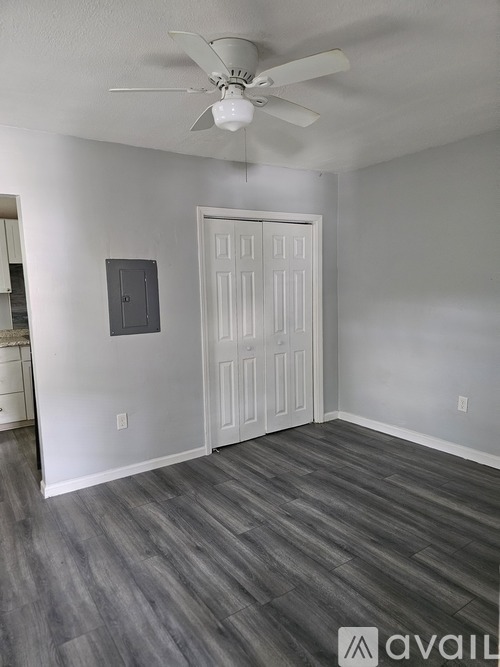 A room with a ceiling fan and a door.