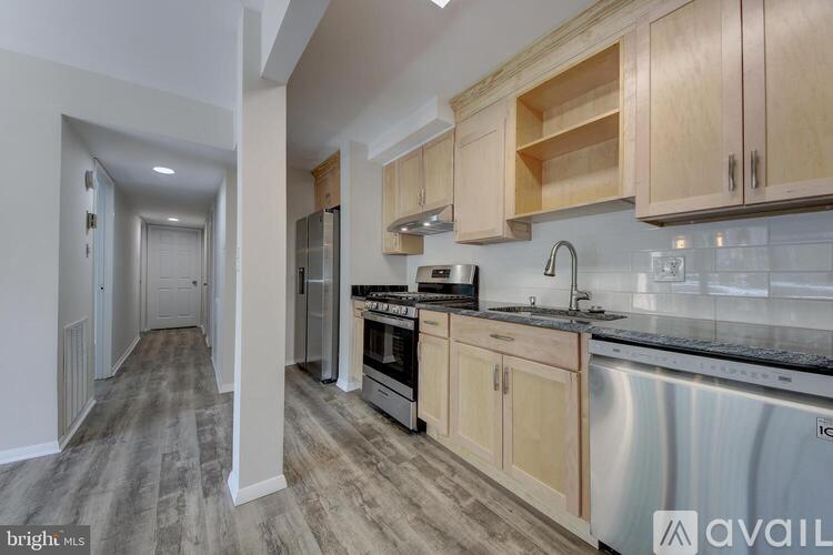 A kitchen with wooden cabinets and a stainless steel refrigerator.