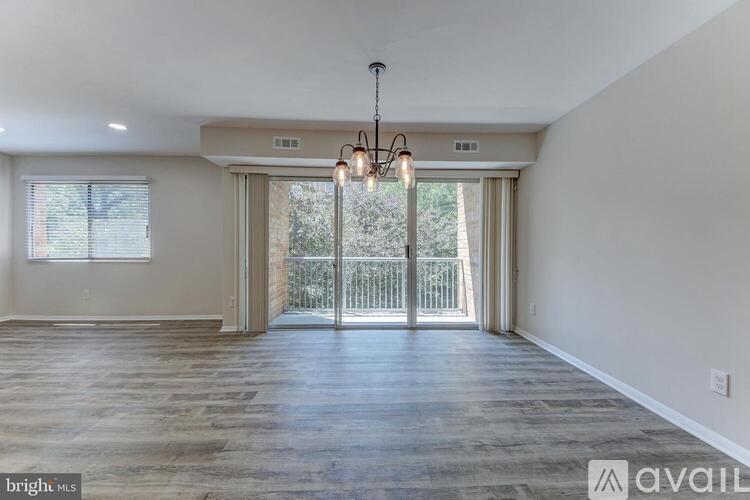 A spacious room with wooden floors and a chandelier.