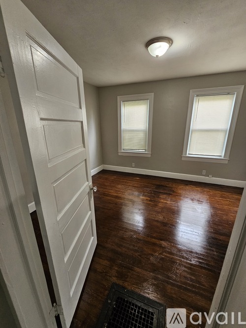 A hallway with wood floors and white walls.