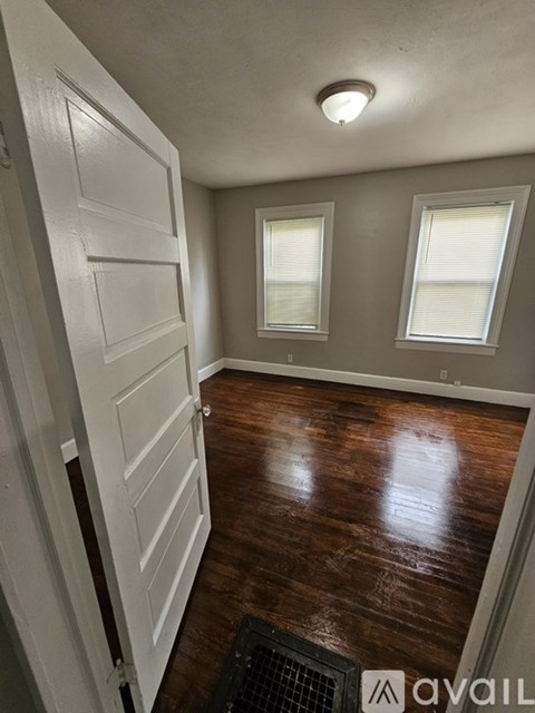 A hallway with wood floors and white walls.