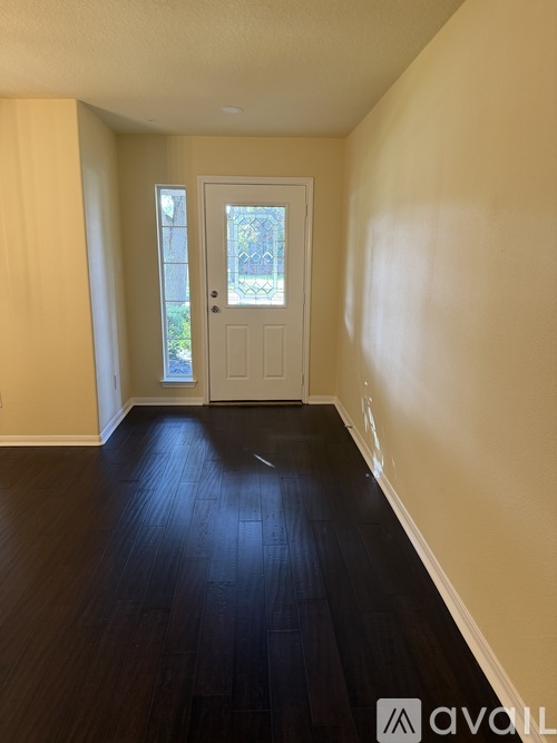 A hallway with a white door and a window.