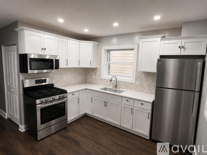 A kitchen with white cabinets and stainless steel appliances.