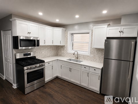 A kitchen with white cabinets and stainless steel appliances.