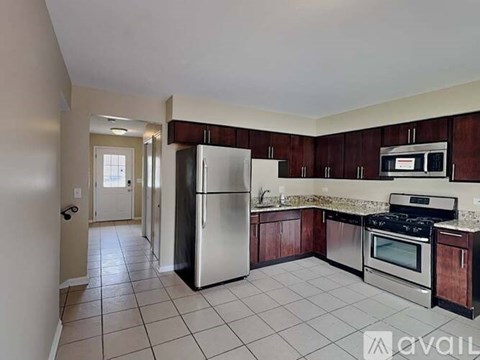 A kitchen with a refrigerator, oven, and microwave.