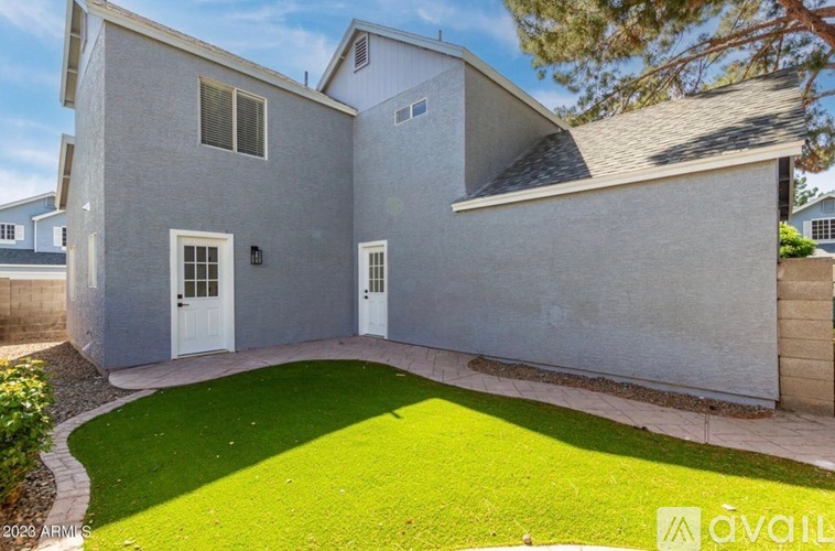 A modern house with a grey exterior and a white door is for sale.