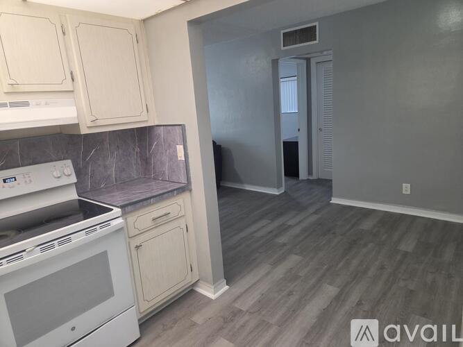 A kitchen with white cabinets and a white stove top oven.