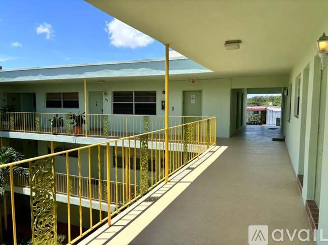 A balcony with a yellow railing and a view of the sky.