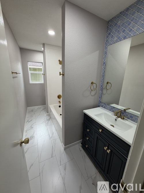 A bathroom with a white sink and a mirror.