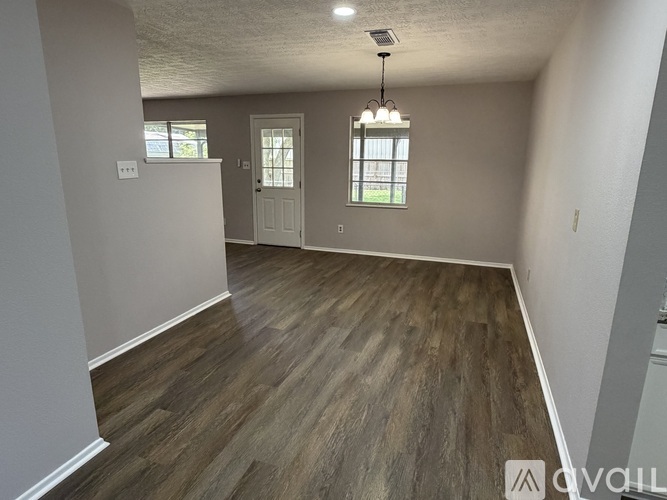 A room with wooden flooring and a window with bars on it.