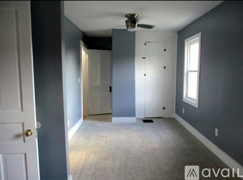 A room with a ceiling fan and a door.