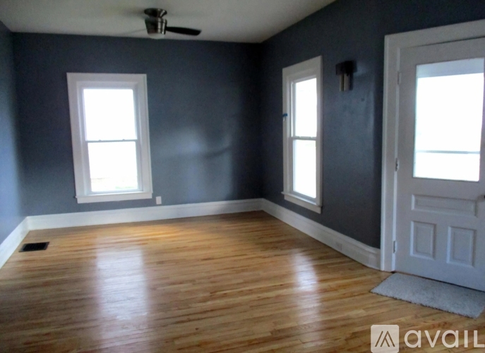 A room with wooden floors and a ceiling fan.