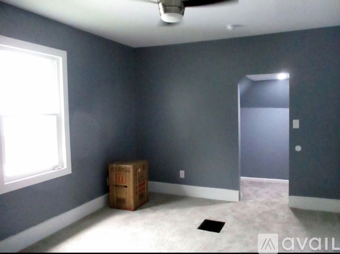 A room with a ceiling fan and a window.