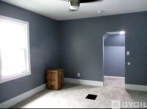 A room with a ceiling fan and a window.