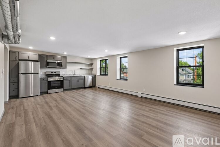 A spacious kitchen with stainless steel appliances and a large window.
