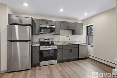 A modern kitchen with stainless steel appliances and wooden floors.