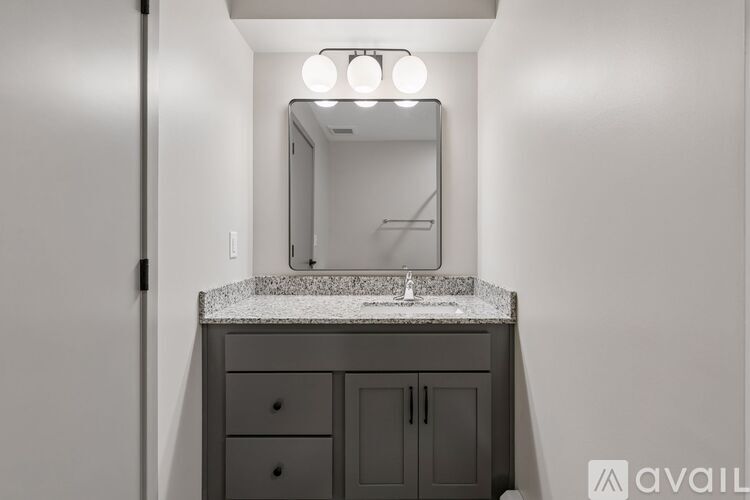 A bathroom vanity with a mirror and lights above it.