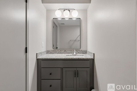 A bathroom vanity with a mirror and lights above it.