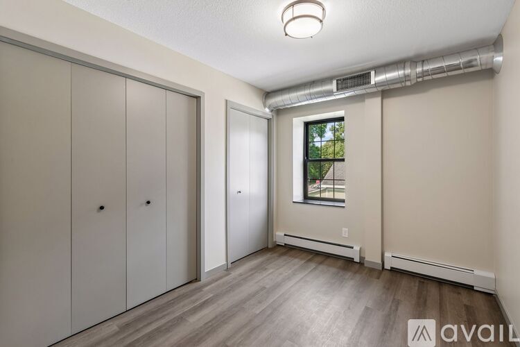 A room with a window and a wall-mounted air conditioner unit.