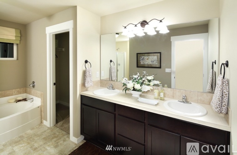 A bathroom with a white sink and a large mirror.