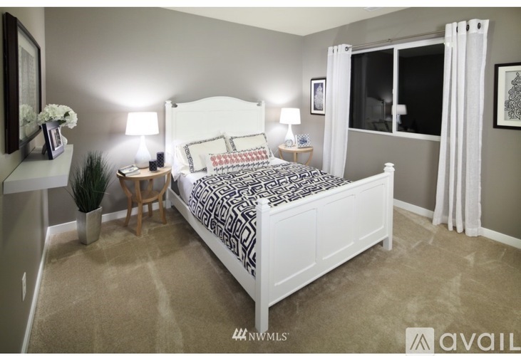 A bedroom with a large bed and a potted plant.