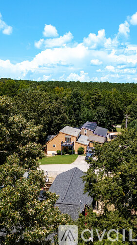 A house surrounded by trees with a clear blue sky above.