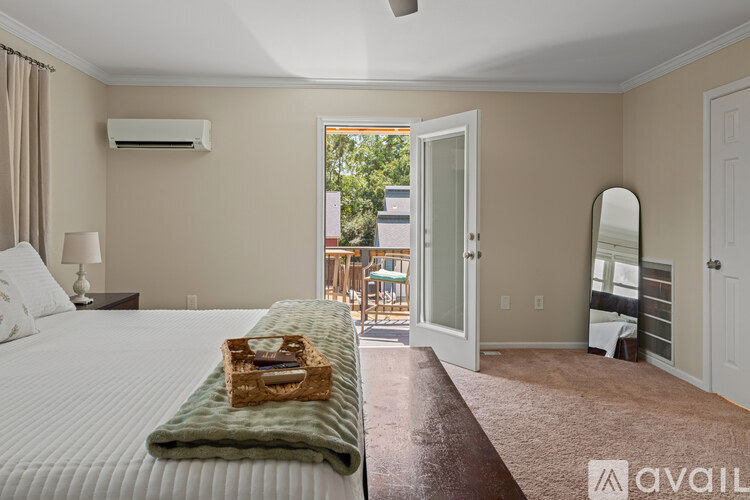 A bedroom with a large bed and a view of the outside through the open door.