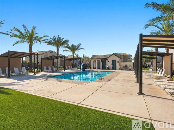A pool area with a clear blue sky and palm trees.
