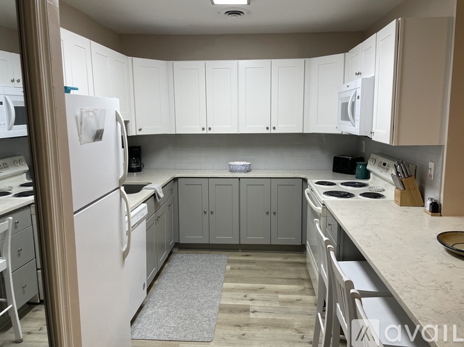 A kitchen with white cabinets and appliances.