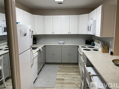 A kitchen with white cabinets and appliances.